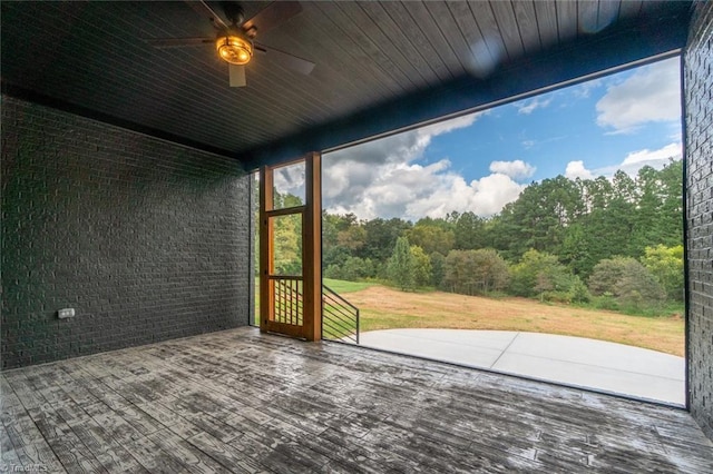 unfurnished sunroom with ceiling fan