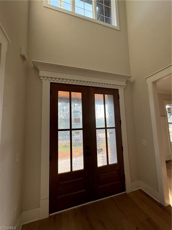 entryway featuring a healthy amount of sunlight, dark hardwood / wood-style floors, and french doors