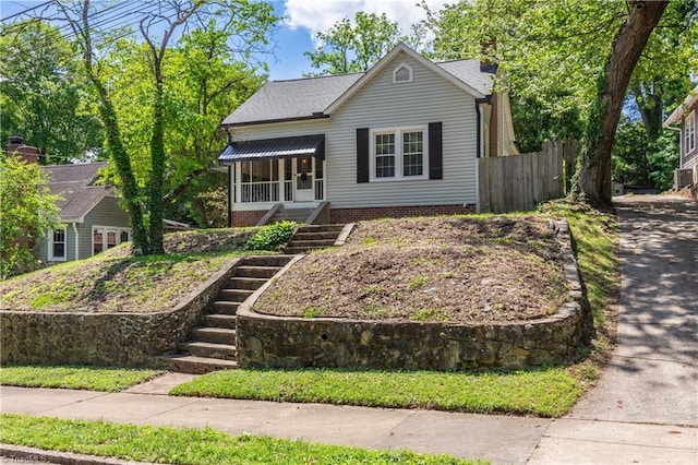 bungalow featuring stairs, fence, and a chimney
