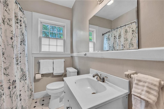 bathroom featuring toilet, vanity, tile walls, a shower with curtain, and tile patterned flooring