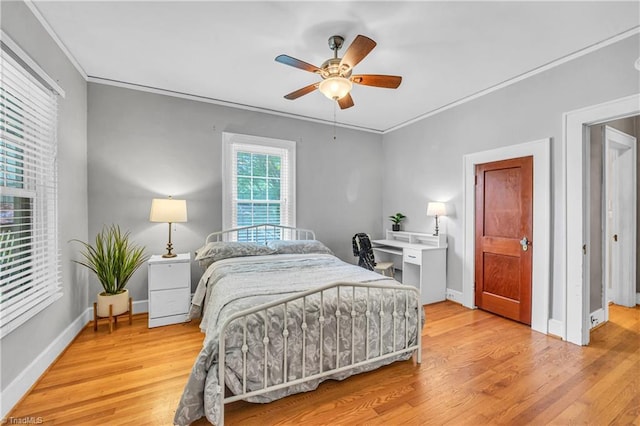 bedroom featuring light wood-style flooring, ornamental molding, baseboards, and a ceiling fan