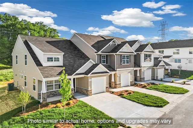 4000 Winding Vine Ln Lot 54, Greensboro, NC 27410 - view of front of house with concrete driveway, central air condition unit, a garage, board and batten siding, and stone siding