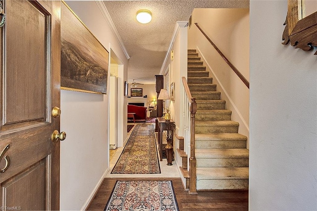 foyer featuring a textured ceiling, crown molding, and dark hardwood / wood-style flooring