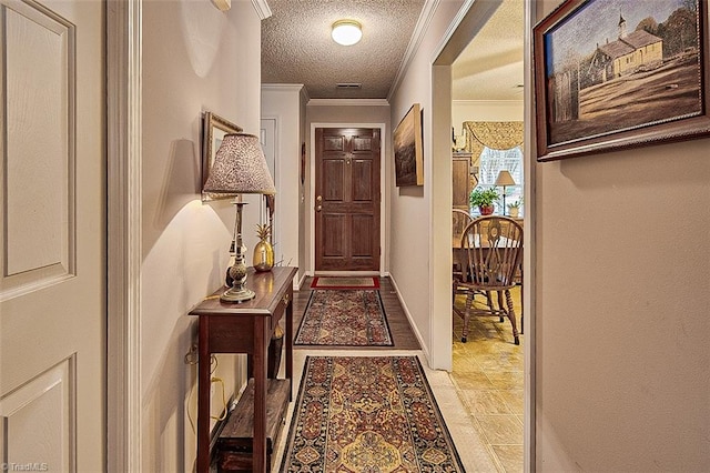 hall with a textured ceiling and crown molding