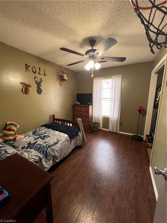 bedroom with ceiling fan, a textured ceiling, and dark hardwood / wood-style flooring