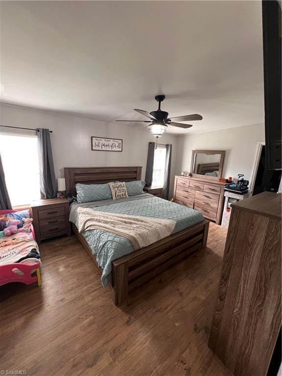 bedroom with dark hardwood / wood-style floors and ceiling fan