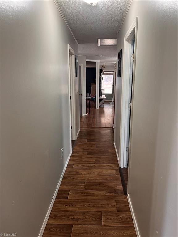 hallway featuring dark hardwood / wood-style floors and a textured ceiling