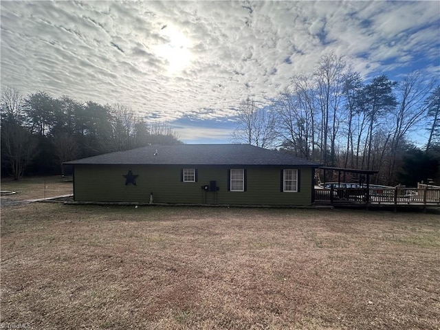 back of property with a yard and a deck