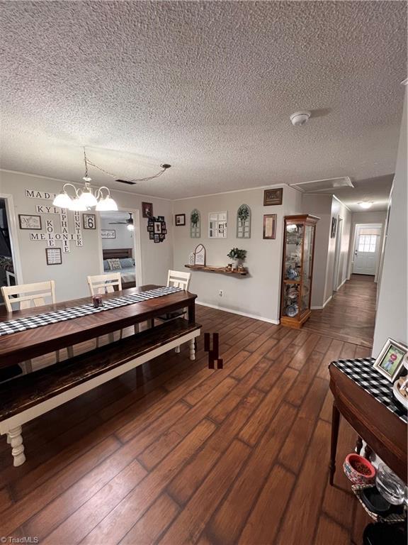 dining room featuring dark wood-type flooring and a textured ceiling