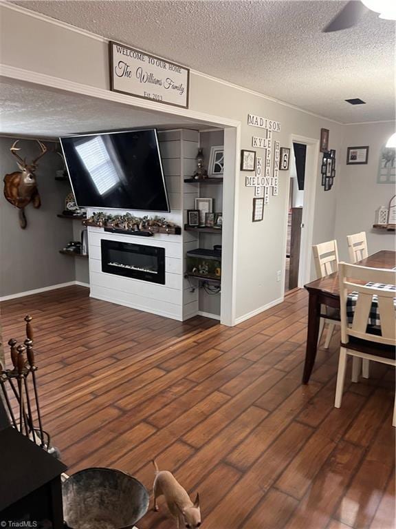 living room with ceiling fan, dark hardwood / wood-style floors, and a textured ceiling