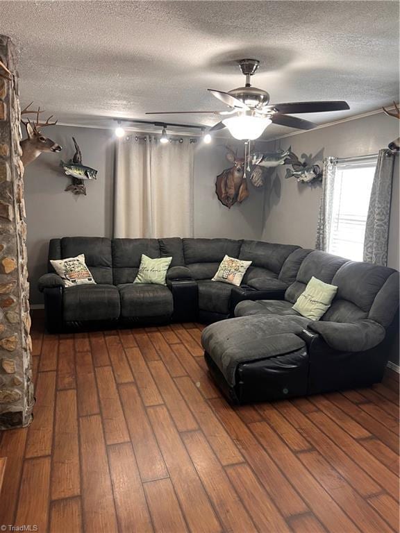 living room featuring hardwood / wood-style floors, a textured ceiling, and ceiling fan