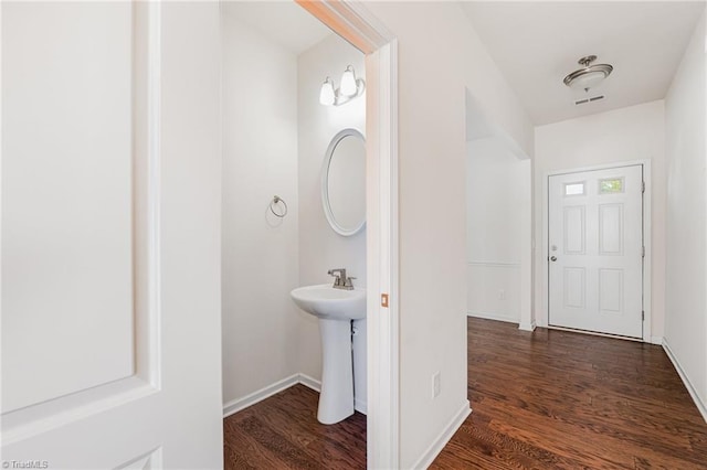 bathroom with a sink, wood finished floors, visible vents, and baseboards