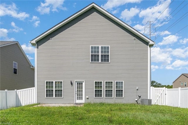 back of property featuring a yard, central AC unit, and a fenced backyard