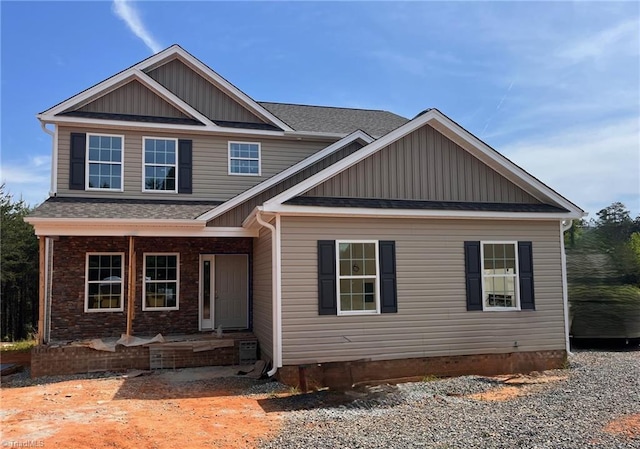 craftsman inspired home featuring roof with shingles, board and batten siding, and a porch