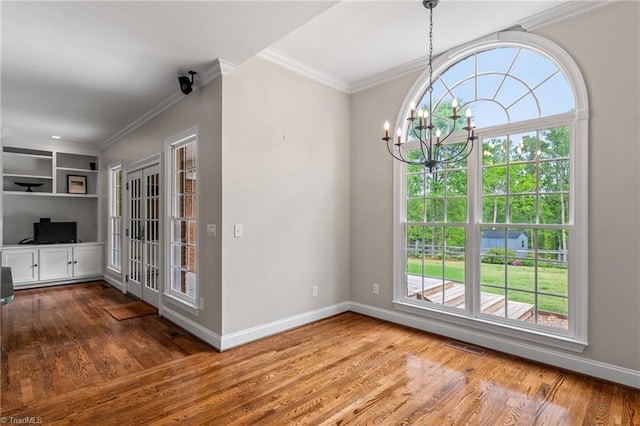 unfurnished dining area featuring baseboards, plenty of natural light, and wood finished floors