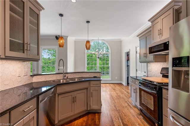 kitchen with crown molding, tasteful backsplash, a sink, light wood-style flooring, and stainless steel appliances