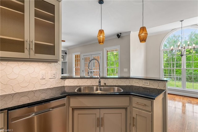 kitchen with stainless steel dishwasher, crown molding, wood finished floors, a sink, and backsplash