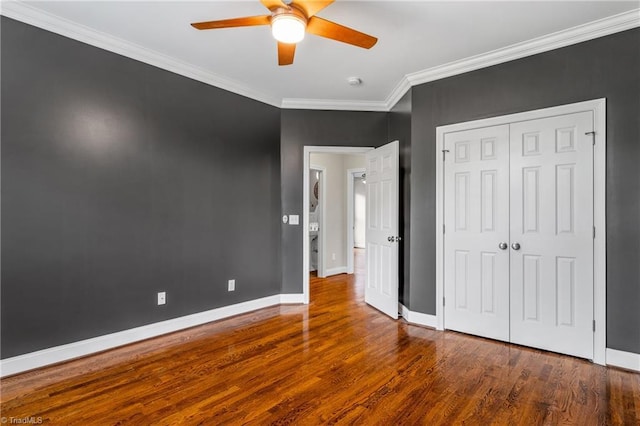 unfurnished bedroom featuring crown molding, baseboards, and wood finished floors