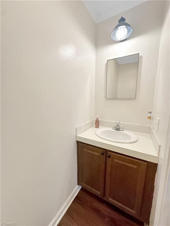 bathroom with vanity, wood-type flooring, and ornamental molding