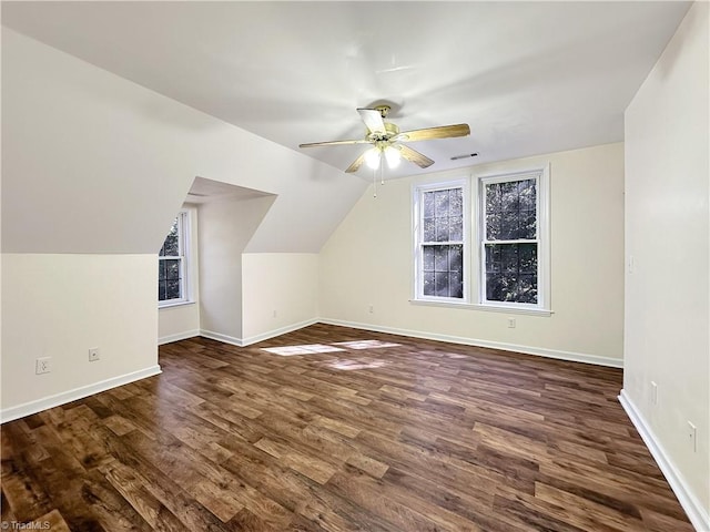 additional living space featuring lofted ceiling, dark hardwood / wood-style floors, plenty of natural light, and ceiling fan