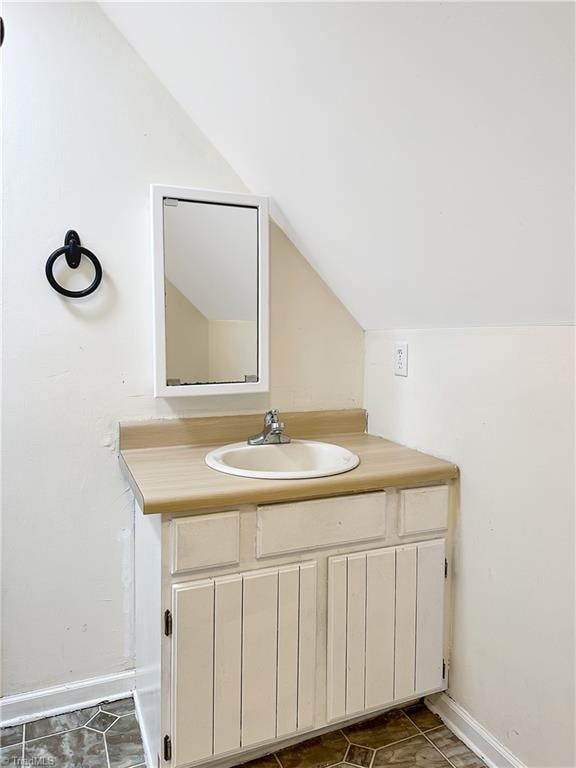 bathroom with vanity and lofted ceiling