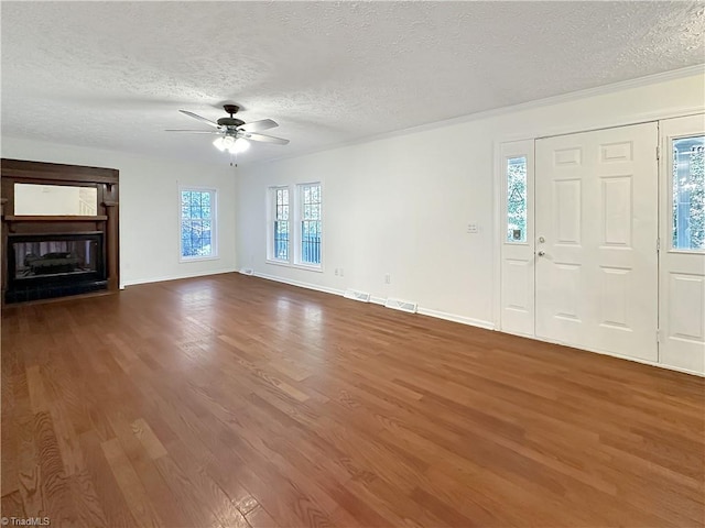 unfurnished living room with a textured ceiling, wood-type flooring, and ceiling fan