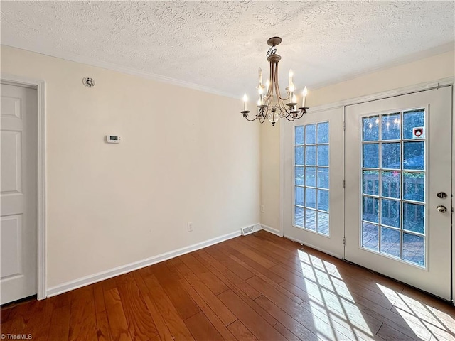 interior space featuring a notable chandelier, a textured ceiling, and wood-type flooring