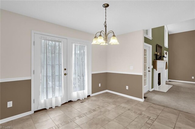 7060 Orchard Path Dr, Clemmons, NC 27012 - unfurnished dining area with a chandelier, baseboards, a fireplace with flush hearth, and french doors