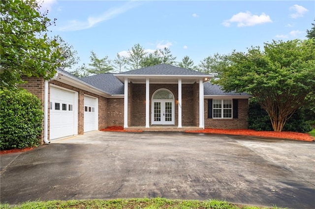 7060 Orchard Path Dr, Clemmons, NC 27012 - greek revival house with french doors, asphalt driveway, an attached garage, and brick siding