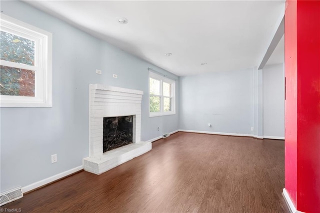 unfurnished living room with a fireplace and dark hardwood / wood-style floors