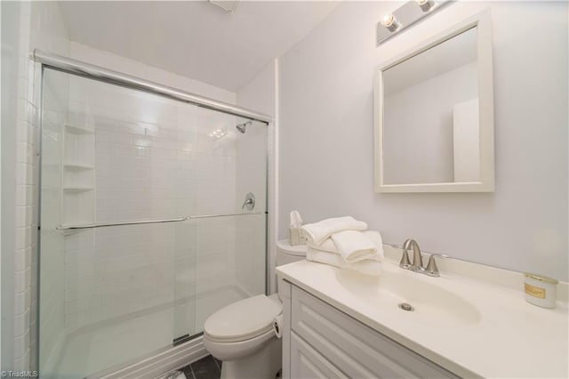 bathroom with vanity, a shower with shower door, and toilet