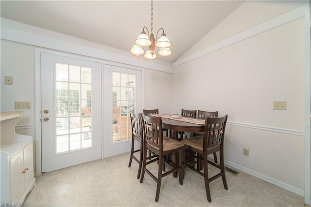 dining area with lofted ceiling and a chandelier