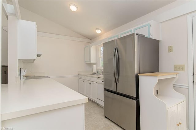 kitchen featuring lofted ceiling, sink, white cabinetry, stainless steel refrigerator, and white dishwasher