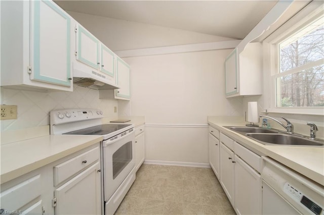 kitchen with lofted ceiling, sink, white appliances, white cabinets, and decorative backsplash