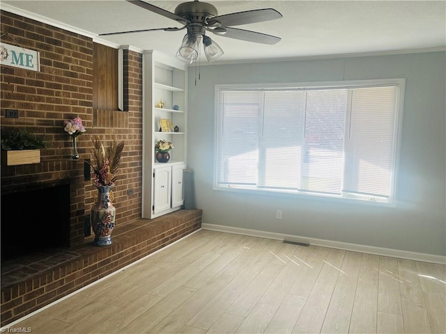 living room with a fireplace, visible vents, baseboards, light wood-type flooring, and crown molding