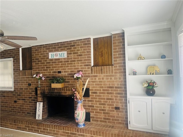 interior space featuring built in features, a brick fireplace, crown molding, and ceiling fan