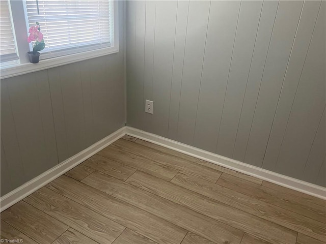 empty room featuring baseboards and wood finished floors