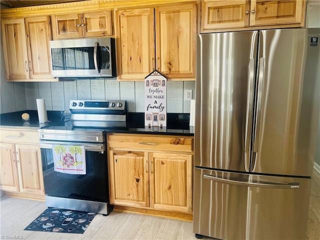 kitchen with dark countertops, tasteful backsplash, and appliances with stainless steel finishes