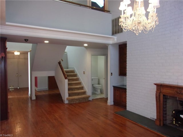 unfurnished living room with a towering ceiling, dark wood-type flooring, and a chandelier