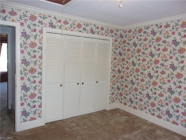 unfurnished bedroom with carpet flooring, a closet, and crown molding