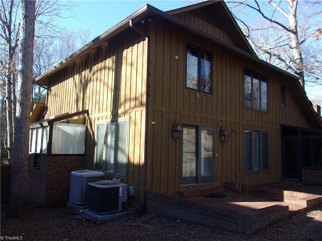 view of side of property with a patio and cooling unit