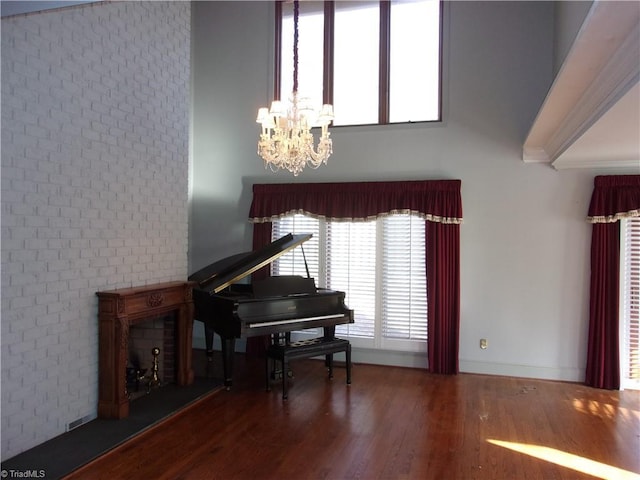 miscellaneous room featuring a chandelier, hardwood / wood-style floors, and brick wall