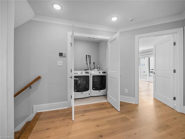 washroom featuring light wood-type flooring, separate washer and dryer, and ornamental molding