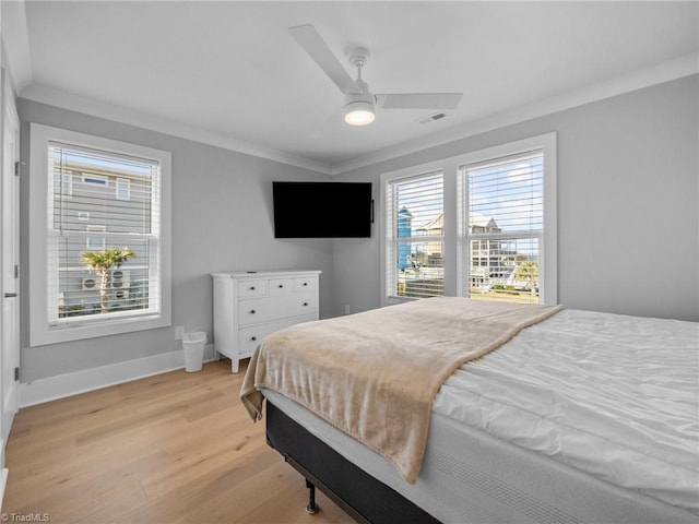 bedroom with light wood-type flooring, ceiling fan, and crown molding