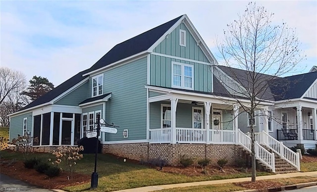 view of front of house featuring a porch, a sunroom, and a front yard