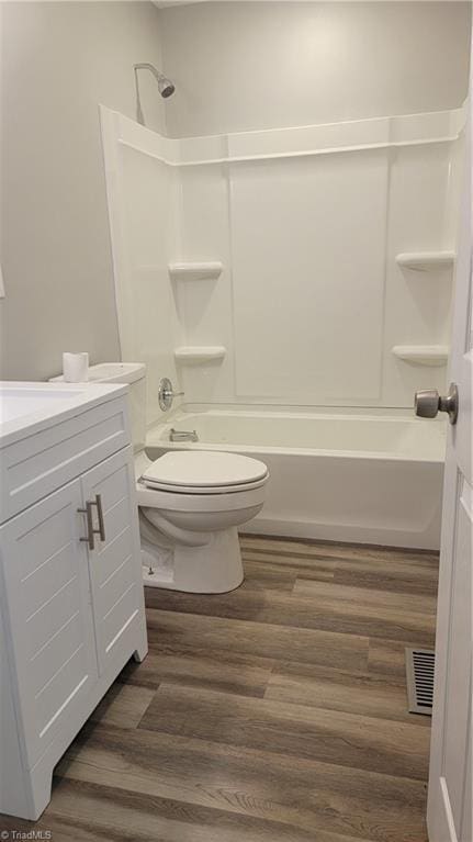 full bathroom with hardwood / wood-style flooring, vanity, toilet, and tub / shower combination