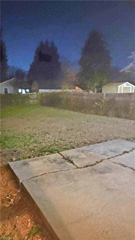 yard at dusk featuring a patio area