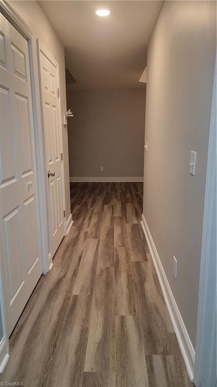 corridor with dark hardwood / wood-style flooring