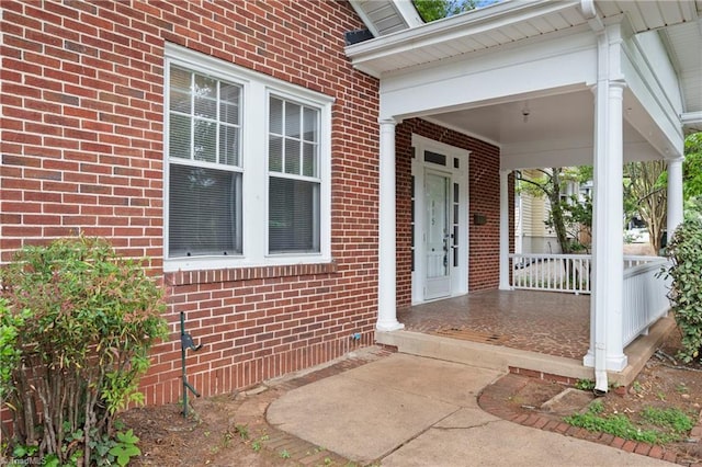 property entrance featuring brick siding and a porch