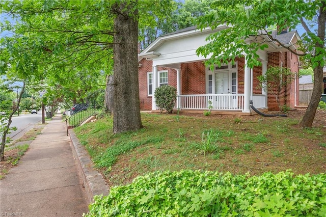view of front of property featuring brick siding and covered porch